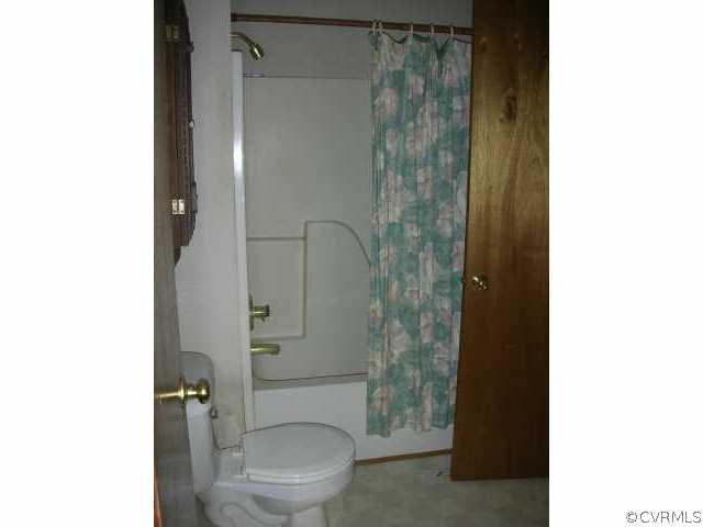 3390 Forest Grove Road Sandy Hook, VA 23153 - Photo 6 of 10 a white toilet sitting next to a shower
