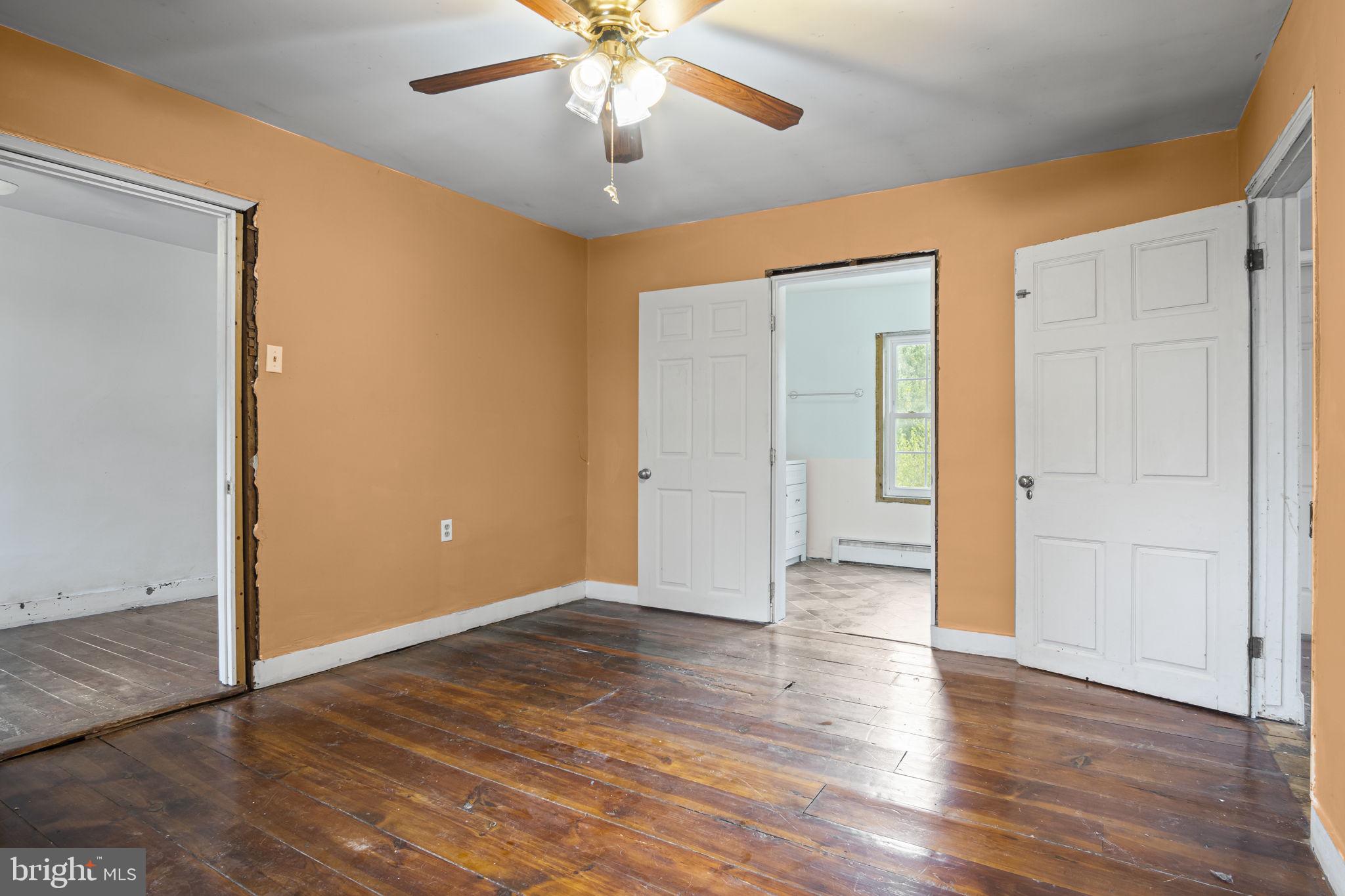 2065 Goldenville Road Gettysburg, PA 17325 - Photo 17 of 51 an empty room with wooden floor chandelier fan and closet area