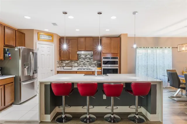 a kitchen that has a lot of cabinets in it and wooden floors