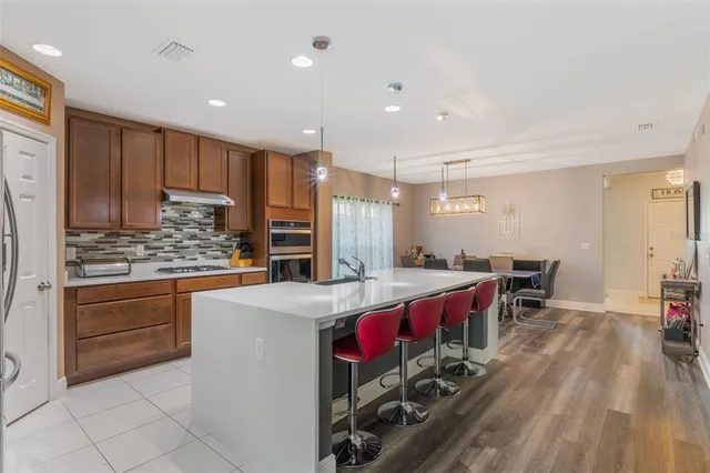 a kitchen with stainless steel appliances granite countertop a sink stove and refrigerator