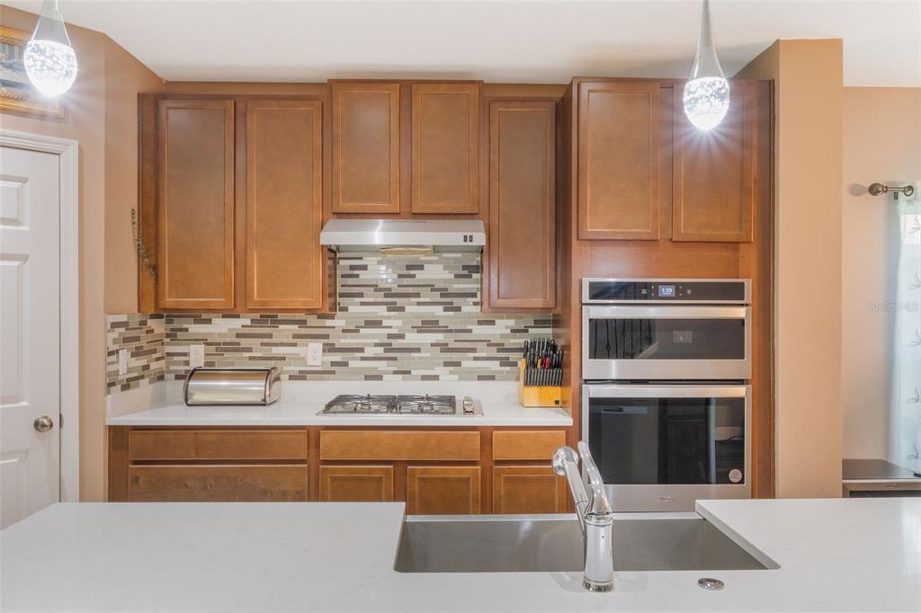 1108 Cavender Creek Road Minneola, FL 34715 - Photo 22 of 54 a kitchen with stainless steel appliances granite countertop a stove and a refrigerator