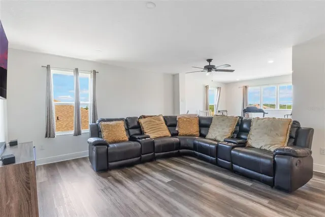 a living room with a bed furniture a chandelier and a window