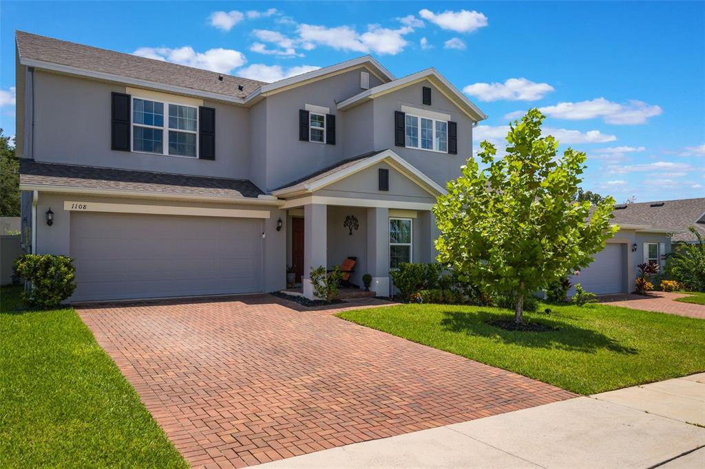 1108 Cavender Creek Road Minneola, FL 34715 - Photo 3 of 54 a front view of a house with a yard and garage