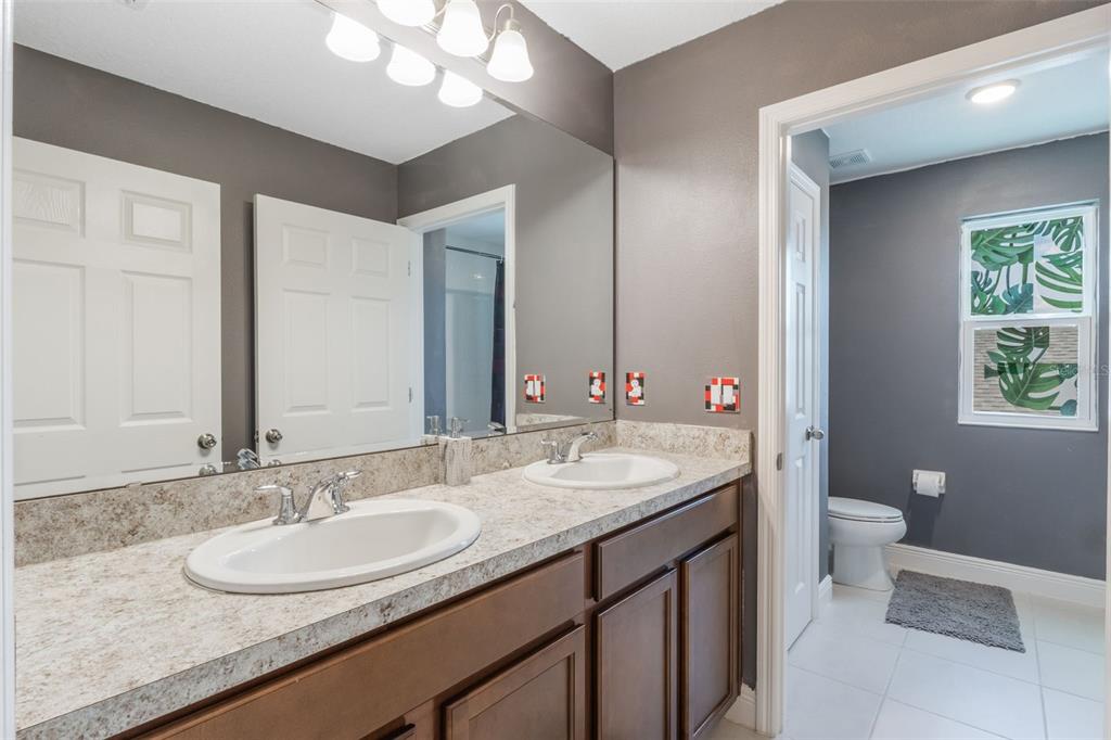 1108 Cavender Creek Road Minneola, FL 34715 - Photo 34 of 54 a bathroom with a double vanity sink and a mirror