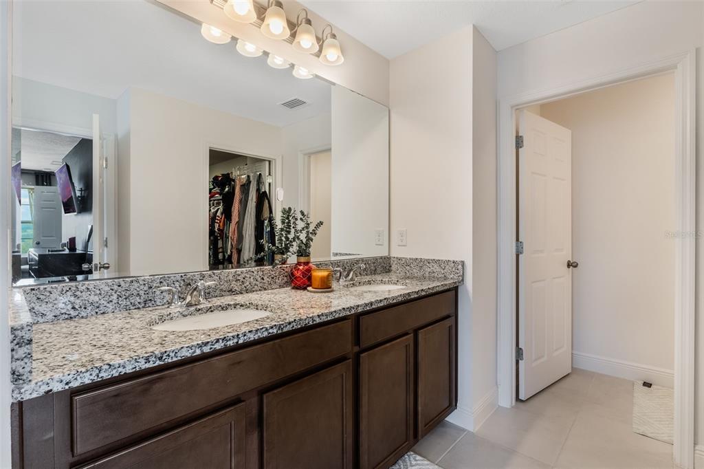 1108 Cavender Creek Road Minneola, FL 34715 - Photo 37 of 54 a bathroom with a granite countertop double vanity sink and a mirror