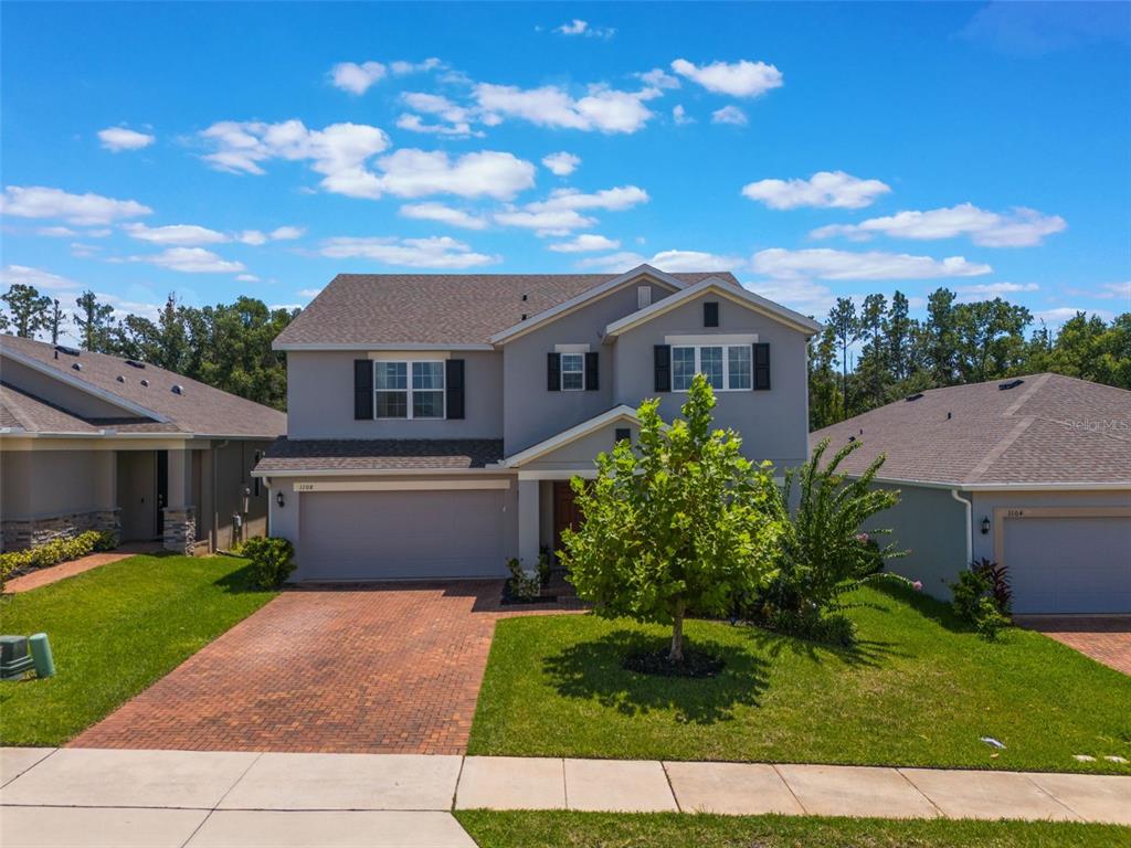 1108 Cavender Creek Road Minneola, FL 34715 - Photo 4 of 54 a front view of a house with a garden