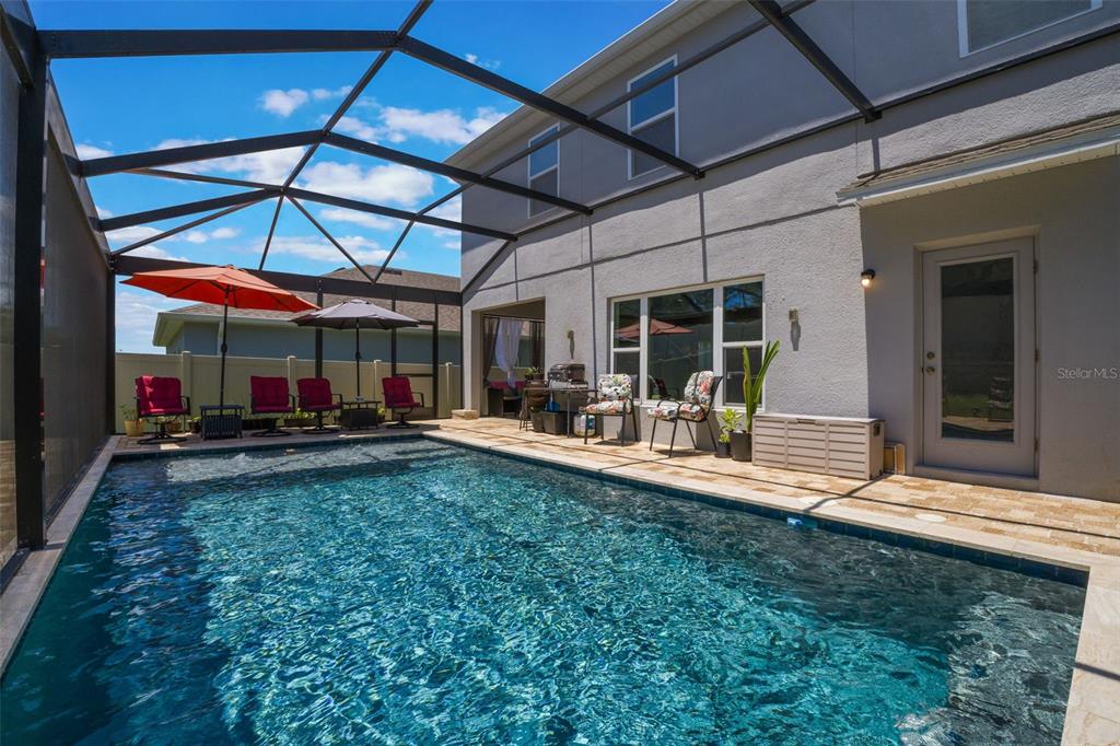 1108 Cavender Creek Road Minneola, FL 34715 - Photo 45 of 54 a view of a backyard with table and chairs under an umbrella