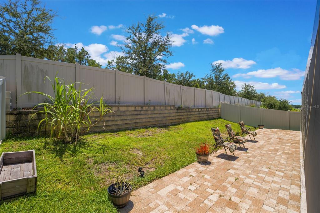 1108 Cavender Creek Road Minneola, FL 34715 - Photo 48 of 54 a view of a backyard with couches plants and wooden fence
