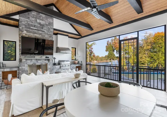 a dining room with furniture a flat screen tv and a floor to ceiling window