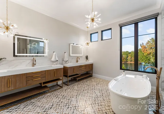 a spacious bathroom with a double vanity sink a mirror and a bathtub