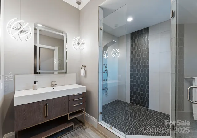 a spacious bathroom with a double vanity sink a mirror and a shower