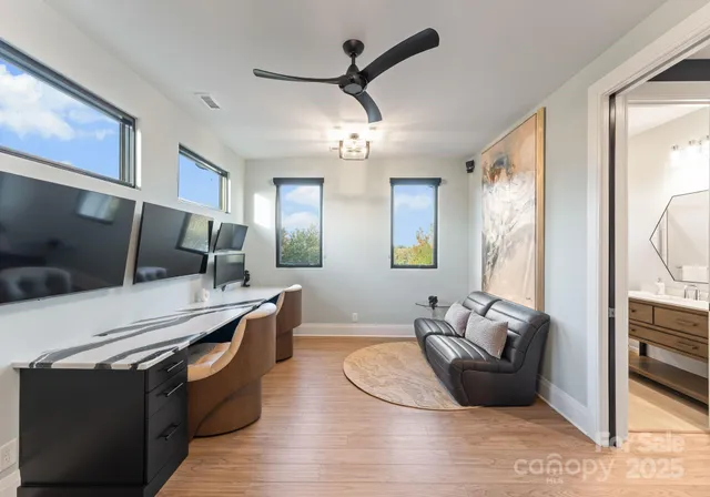 a living room with stainless steel appliances kitchen island granite countertop furniture a rug a flat screen tv and a window