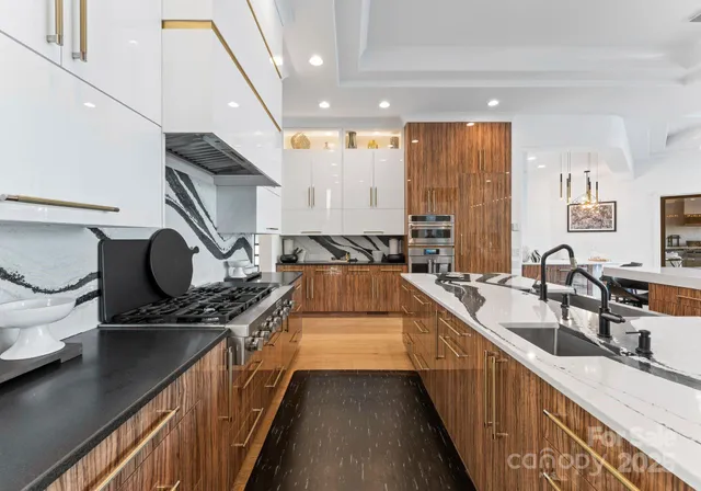 a kitchen with kitchen island granite countertop a sink stove and cabinets
