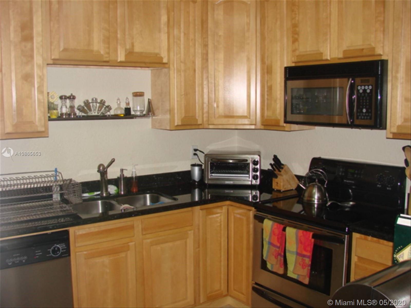 6801 Southwest 83rd Place Miami, FL 33143 - Photo 3 of 6 a kitchen with stainless steel appliances granite countertop a stove a sink and a microwave