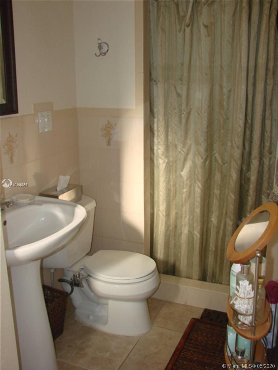 6801 Southwest 83rd Place Miami, FL 33143 - Photo 5 of 6 a white toilet sitting next to a shower curtain