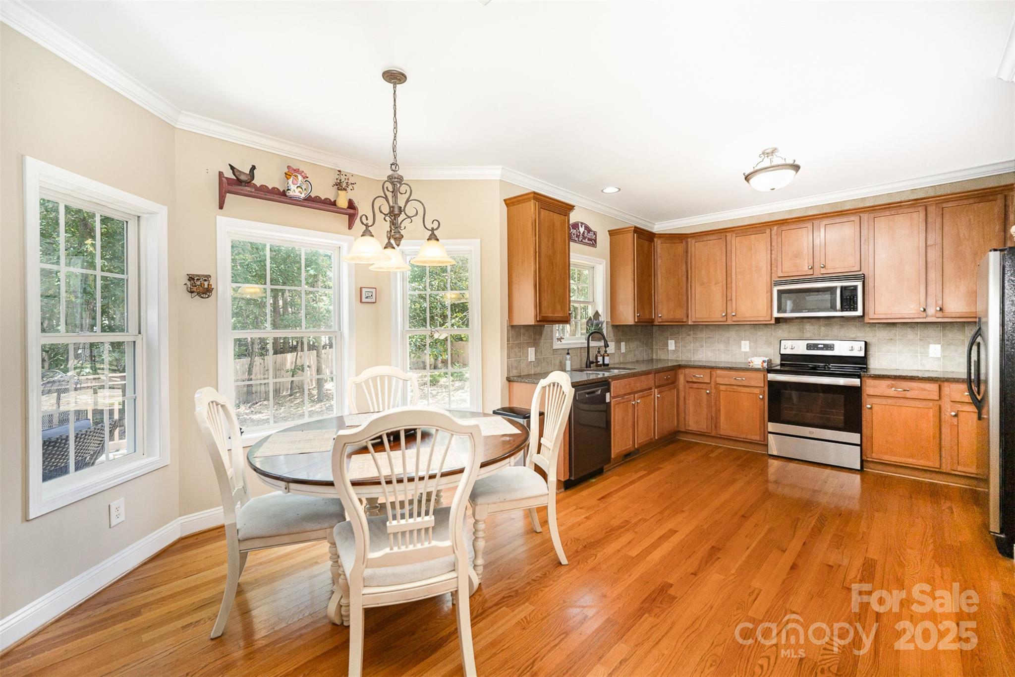 1846 Sam Smith Road Fort Mill, SC 29708 - Photo 11 of 33 a kitchen with stainless steel appliances granite countertop a stove top oven a sink dishwasher a dining table and chairs with wooden floor