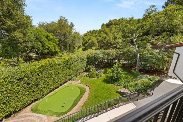 a view of a swimming pool with a garden and trees