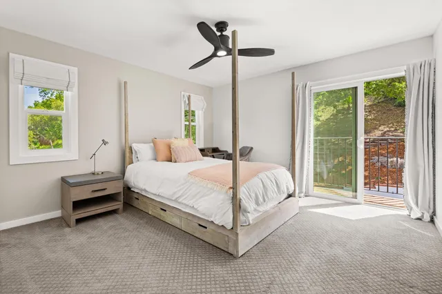 a bed sitting in a spacious bedroom next to a window