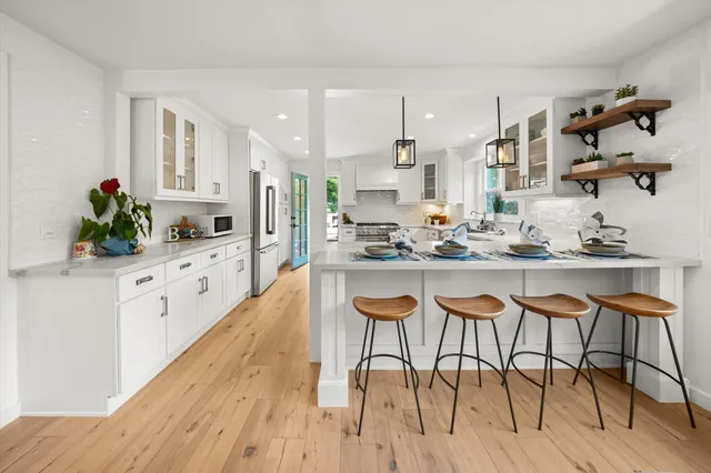 a kitchen with stainless steel appliances kitchen island granite countertop a table and chairs in it