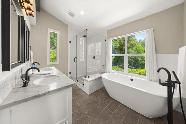 a bathroom with a large tub sink and mirror