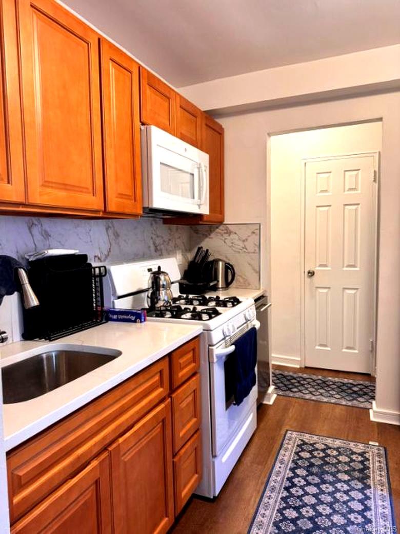 4320 Van Cortlandt Park East, Unit 6E Bronx, NY 10470 - Photo 5 of 11 a kitchen with stainless steel appliances granite countertop a stove a sink and a microwave