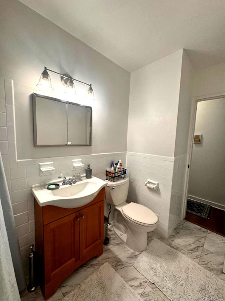 4320 Van Cortlandt Park East, Unit 6E Bronx, NY 10470 - Photo 8 of 11 a bathroom with a toilet sink and mirror