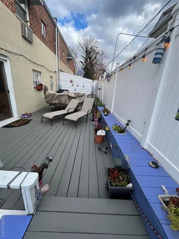 a roof deck with table and chairs with wooden floor