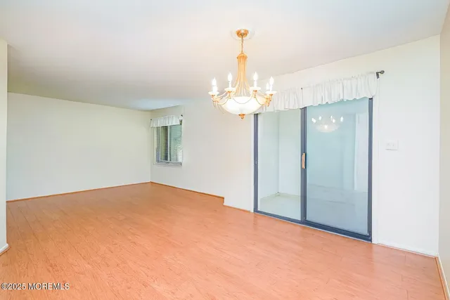 a view of an empty room with a chandelier fan