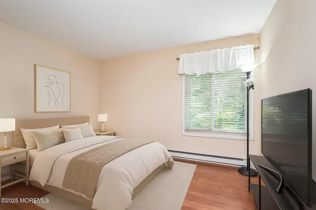 a bedroom with a bed tv and a window