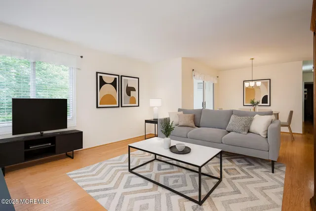 a living room with furniture a flat screen tv and a window