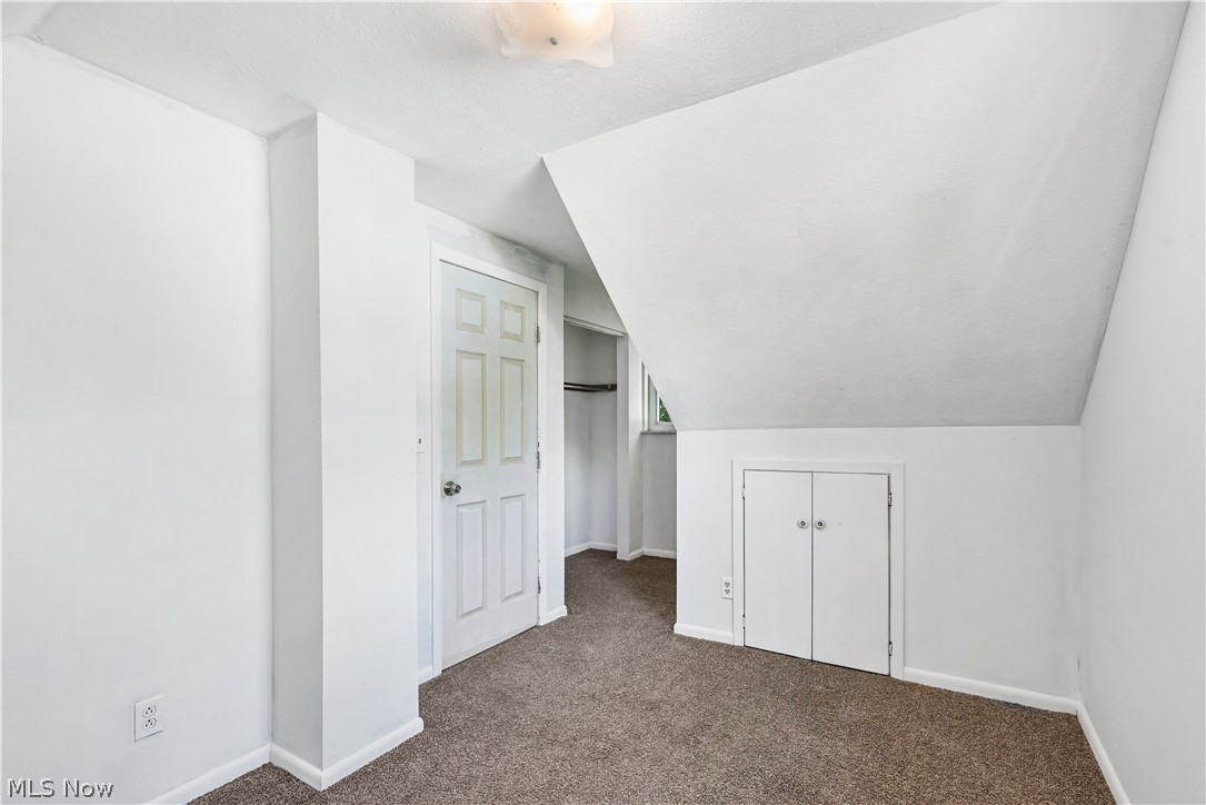 1286 Deforest Road Southeast Warren, OH 44484 - Photo 13 of 27 Room featuring an angled ceiling, neutral wall paint, and brown carpet flooring