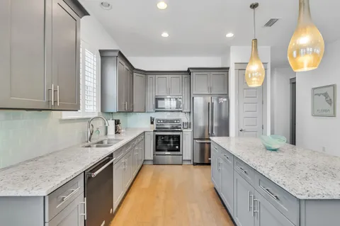 a large kitchen with granite countertop a stove oven and a sink