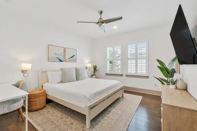 a bedroom with a bed wooden floor and a flat screen tv