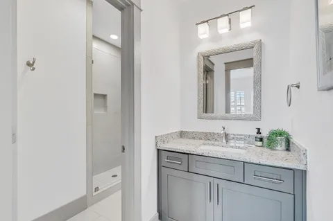 a bathroom with a granite countertop sink and a mirror