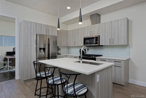 a kitchen with stainless steel appliances a microwave sink stove refrigerator and cabinets