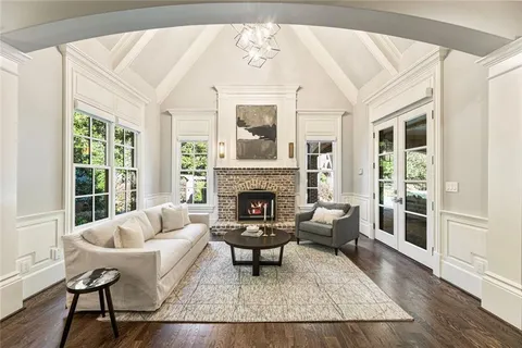a living room with furniture a chandelier and a fireplace