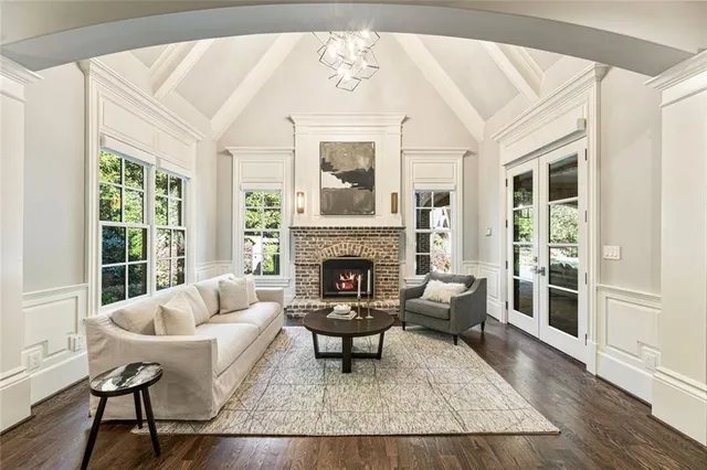 a living room with furniture a chandelier and a fireplace