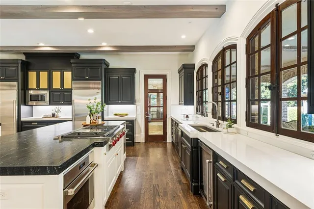 a kitchen with stainless steel appliances granite countertop a refrigerator and a stove top oven