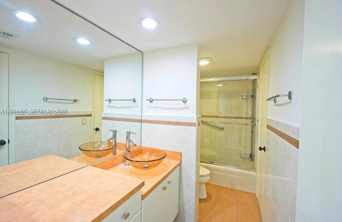 7401 Southwest 82nd Street, Unit 207S Miami, FL 33143 - Photo 9 of 15 a bathroom with a granite countertop sink and a mirror