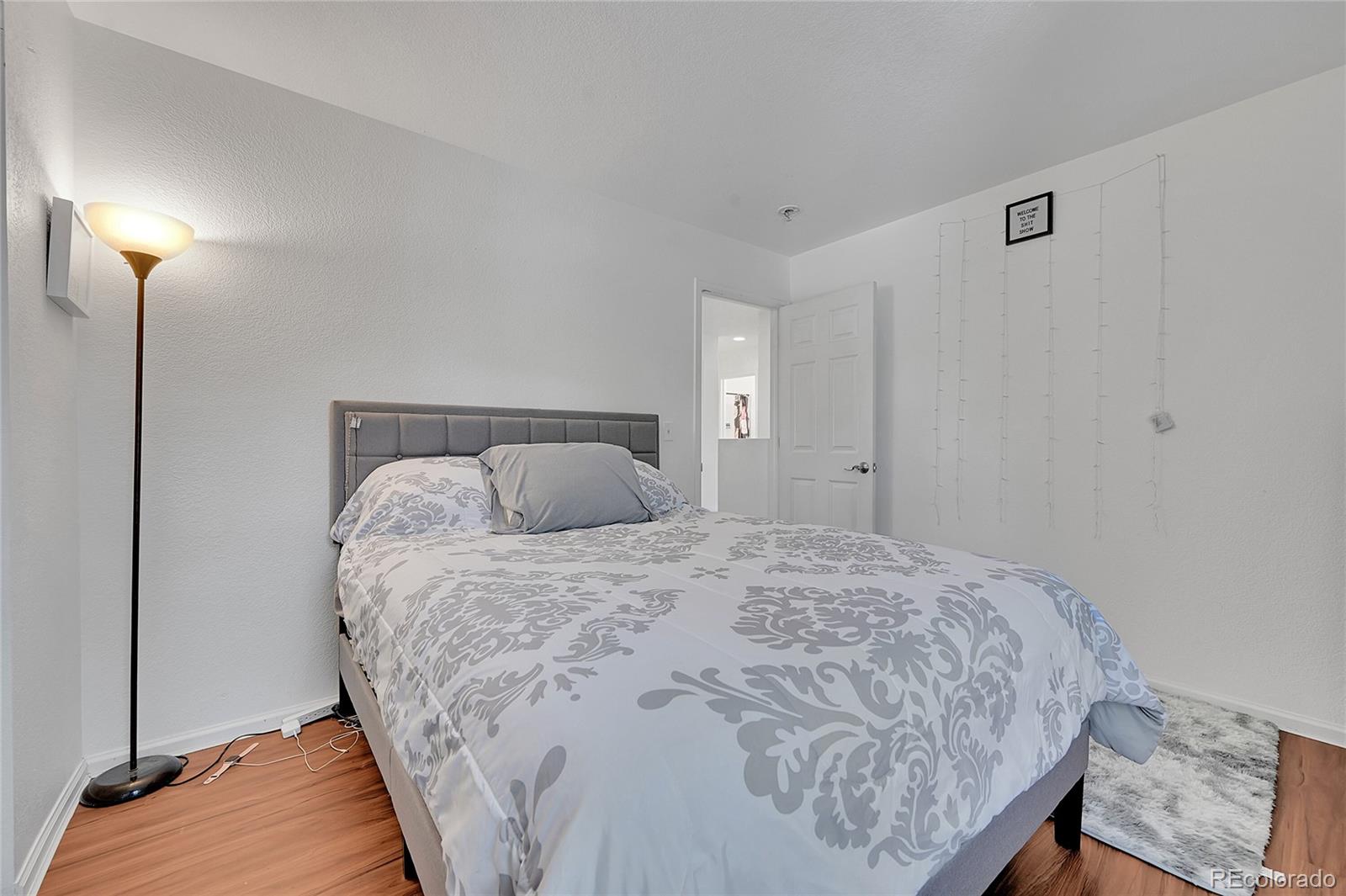 1489 Hummingbird Circle Brighton, CO 80601 - Photo 18 of 46 a bedroom with a bed and a lamp