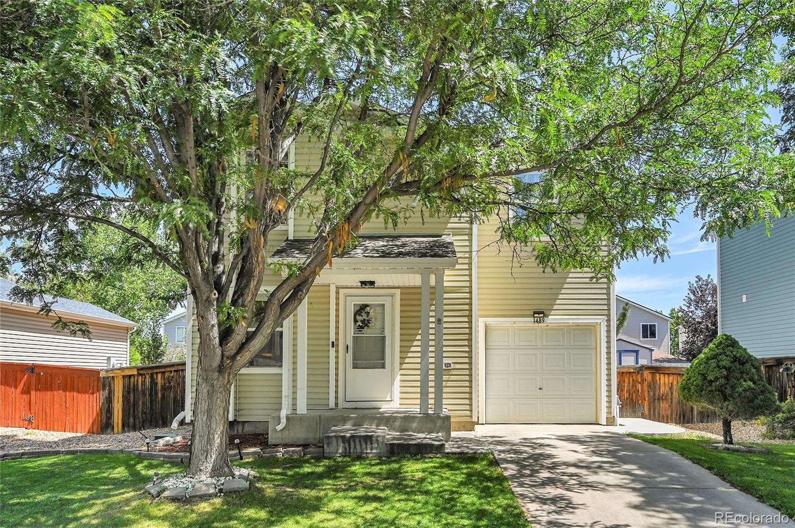 1489 Hummingbird Circle Brighton, CO 80601 - Photo 45 of 46 front view of a house with a tree