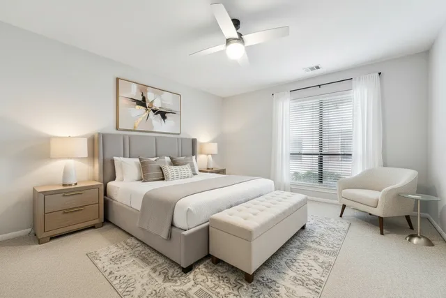 a bedroom with a bed a couch and a window