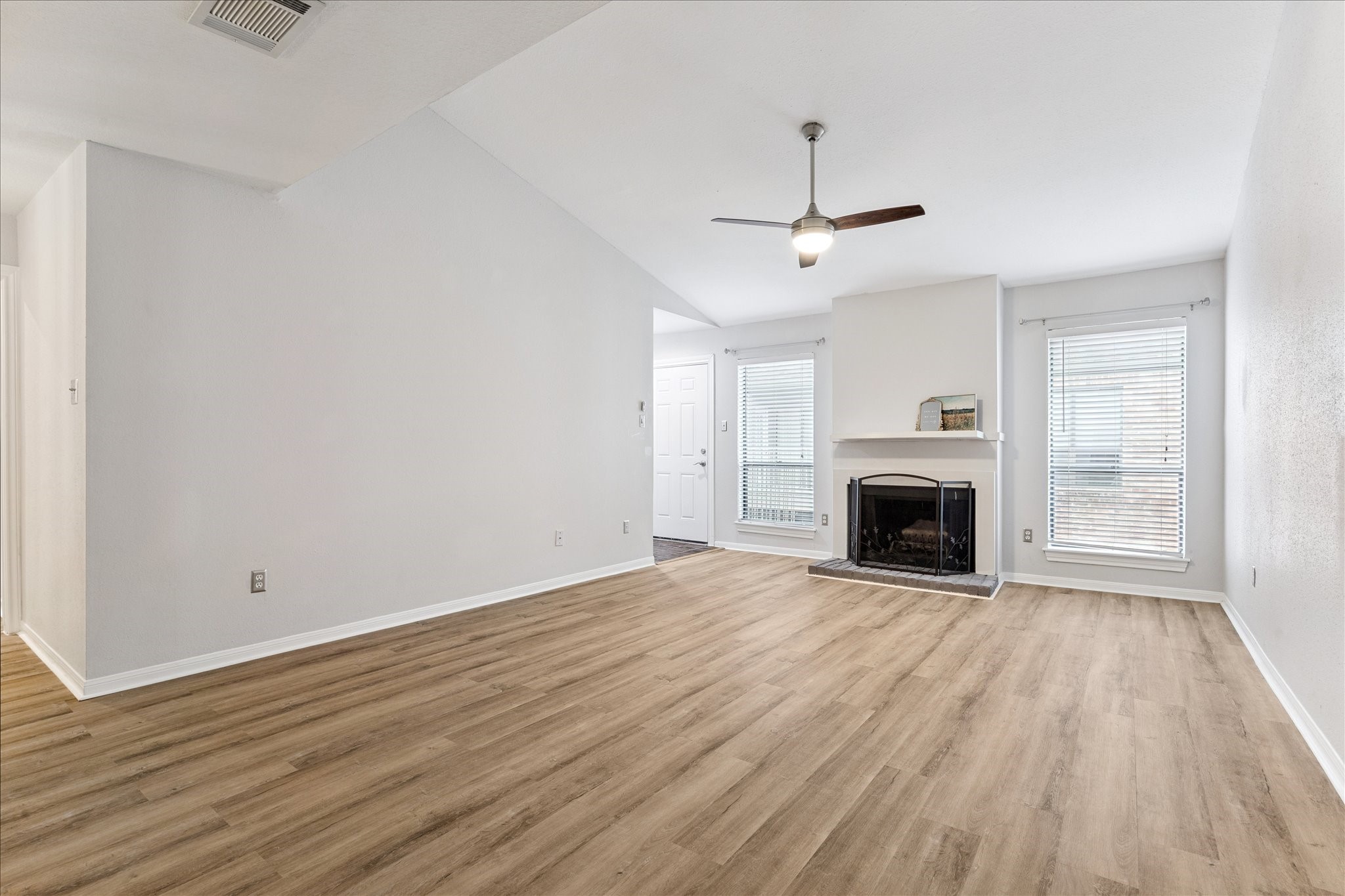 1201 Bering Drive, Unit 100 Houston, TX 77057 - Photo 4 of 20 an empty room with wooden floor fireplace and windows