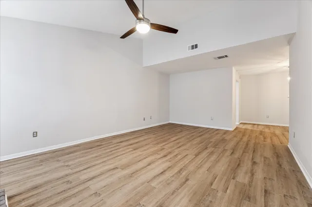 a view of empty room with wooden floor