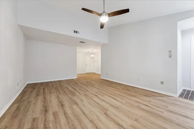 a view of empty room with wooden floor