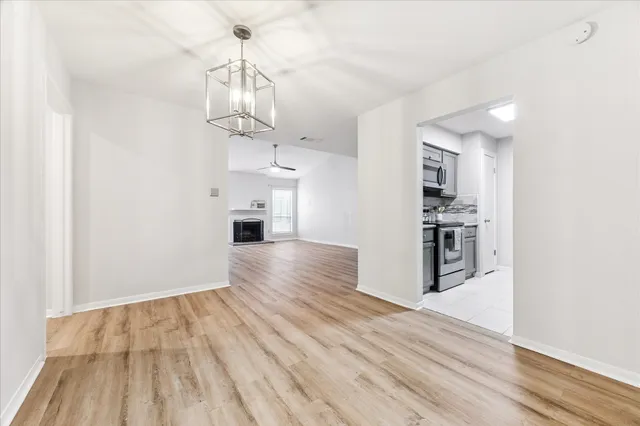 a view of a kitchen with wooden floor and a ceiling fan