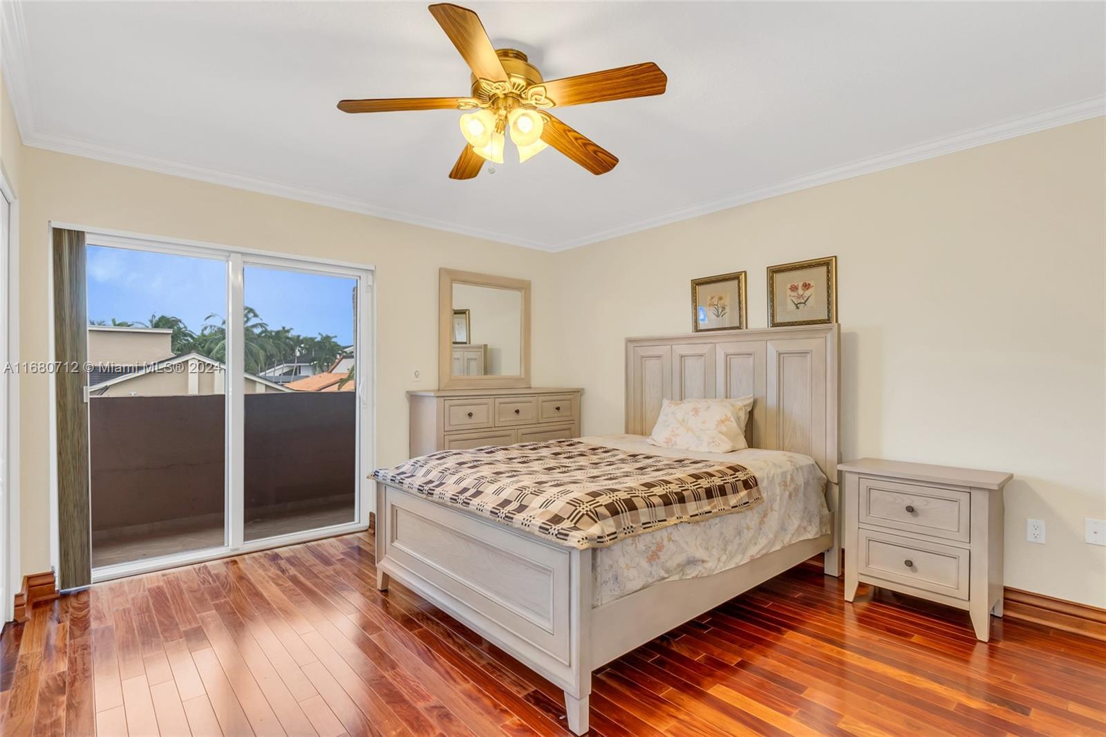 11451 Southwest 103rd Street Miami, FL 33176 - Photo 13 of 23 a bedroom with a bed and a dresser with wooden floor