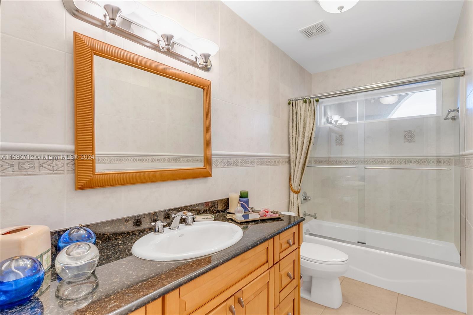 11451 Southwest 103rd Street Miami, FL 33176 - Photo 14 of 23 a bathroom with a granite countertop sink mirror vanity and toilet