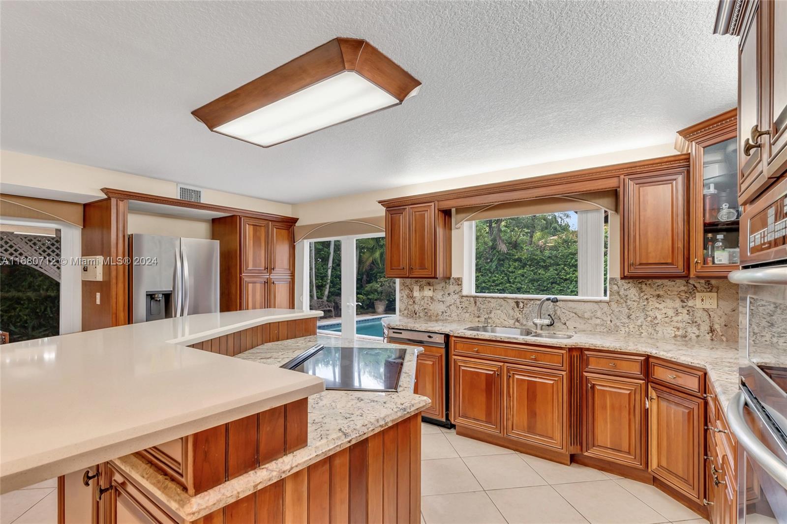 11451 Southwest 103rd Street Miami, FL 33176 - Photo 6 of 23 a kitchen with a stove a sink and a wooden cabinets