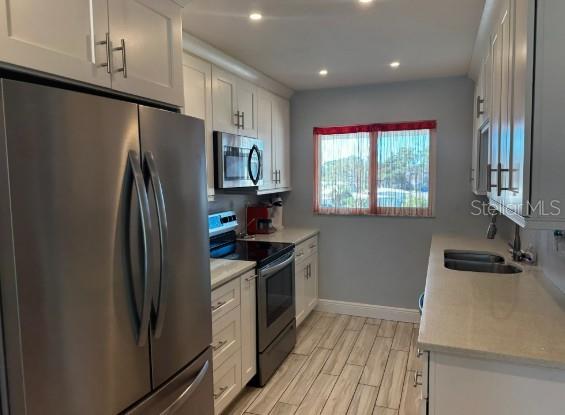708 South Tamiami Trail, Unit 318 Venice, FL 34285 - Photo 4 of 13 a kitchen with stainless steel appliances a refrigerator stove and sink